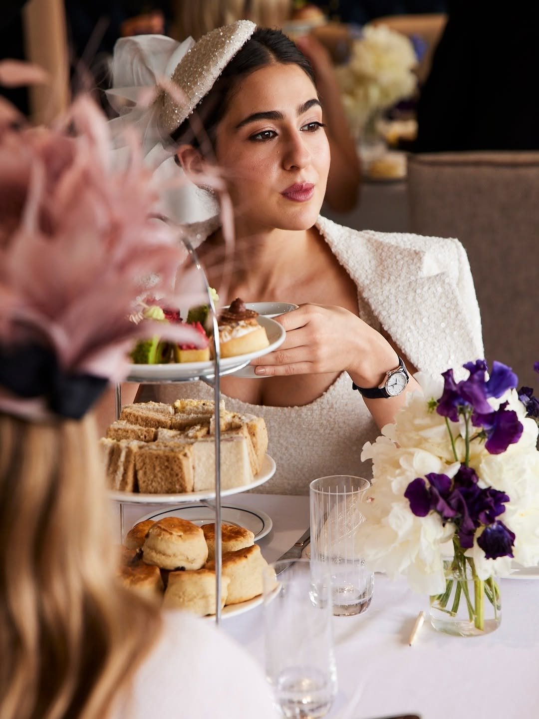 Sara Ali Khan সাজানো টেবিলে afternoon tea উপভোগ করছেন, সামনে three tier স্ট্যান্ডে সাজানো পেস্ট্রি ও sandwich