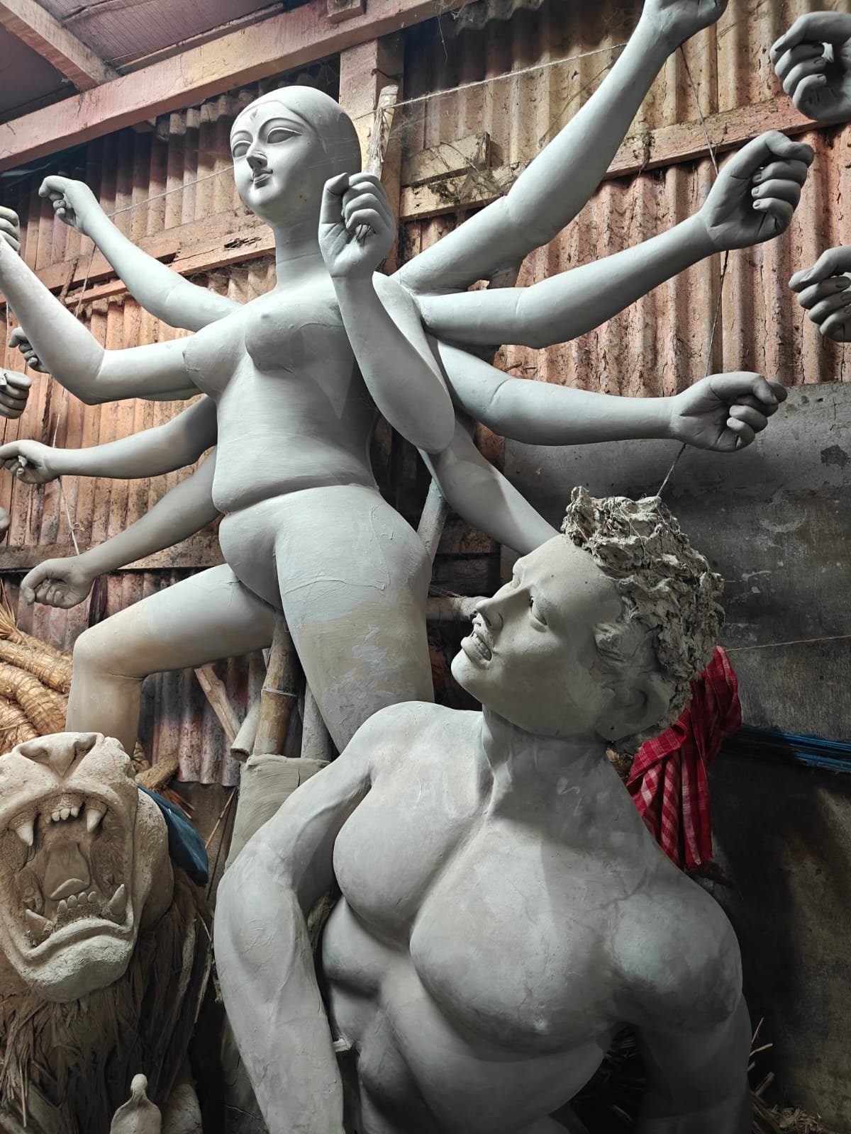 কুমোরপাড়ায় রং লাগানোর আগে মাটির দুর্গা প্রতিমা এবং অসুরের কাঠামো তৈরির দৃশ্য